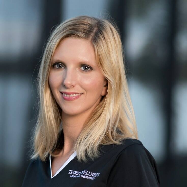 Smiling blonde woman in massage therapy uniform