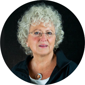 Professional headshot of older woman wearing glasses